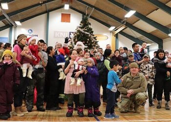 A community gathering of children and families in Greenland during a festive event, illustrating the youth and local life in Nuuk
