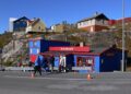 Colorful wooden houses in a Greenlandic settlement overlooking a frozen fjord