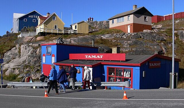Colorful wooden houses in a Greenlandic settlement overlooking a frozen fjord