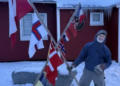 Legendary explorer Jens Kjeldsen holding flags during a protest in Nuuk, Greenland