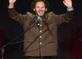 German comedian Maxi Schafroth performing on stage, involved in the controversial US flag incident in Nuuk, Greenland