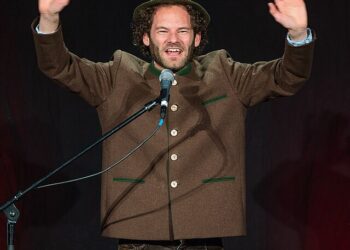 German comedian Maxi Schafroth performing on stage, involved in the controversial US flag incident in Nuuk, Greenland