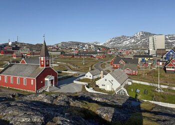 Panoramic view of Greenlandic coastal town with traditional colorful houses and Arctic sea