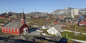Panoramic view of Greenlandic coastal town with traditional colorful houses and Arctic sea